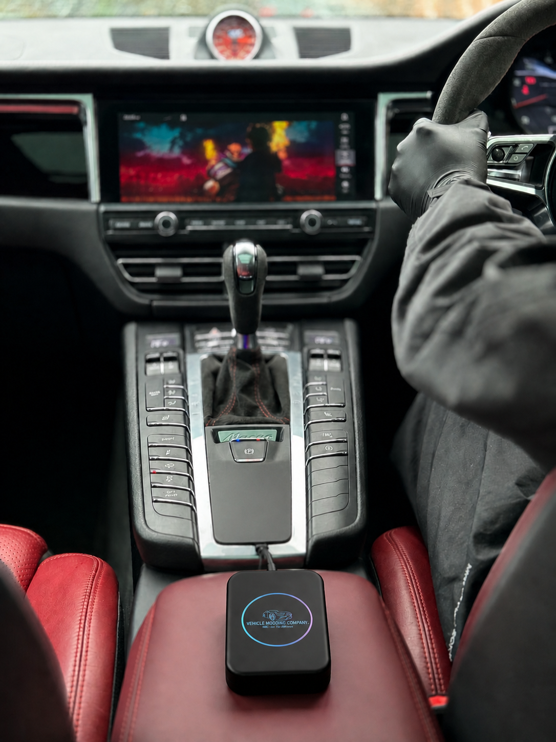 VMC Multimedia Box plugged into Porsche Macan, screen showing video playing whilst car is in motion